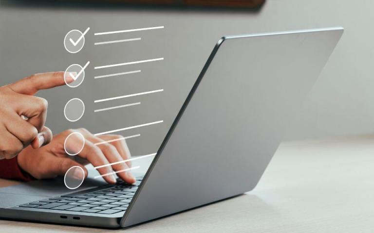 person at laptop touching digital checklist