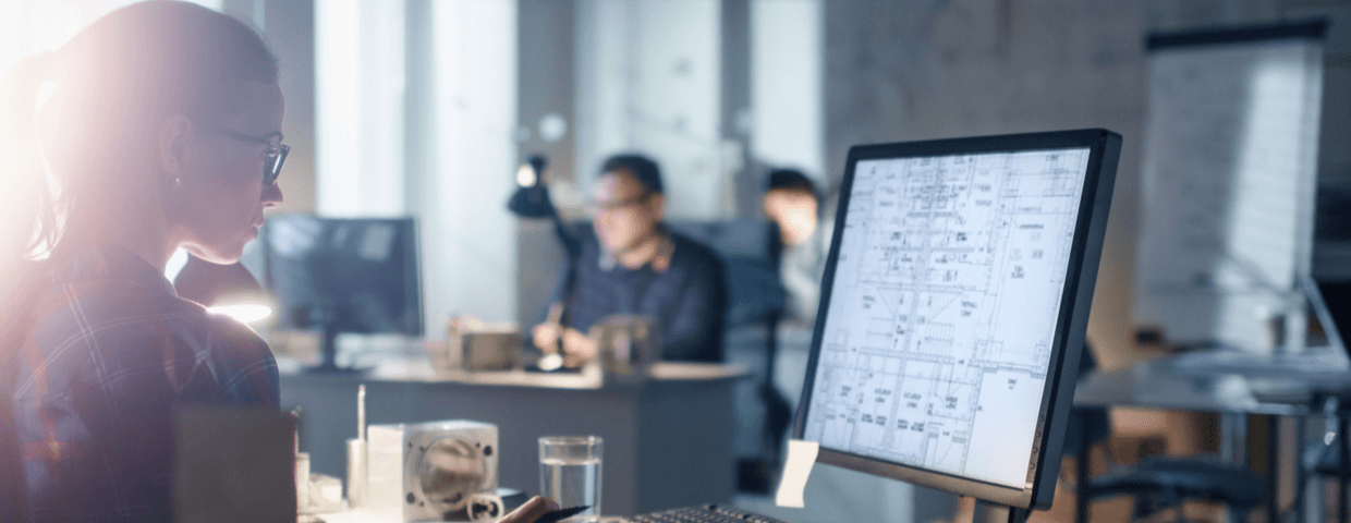 Young woman engineer working at office desk on computer.