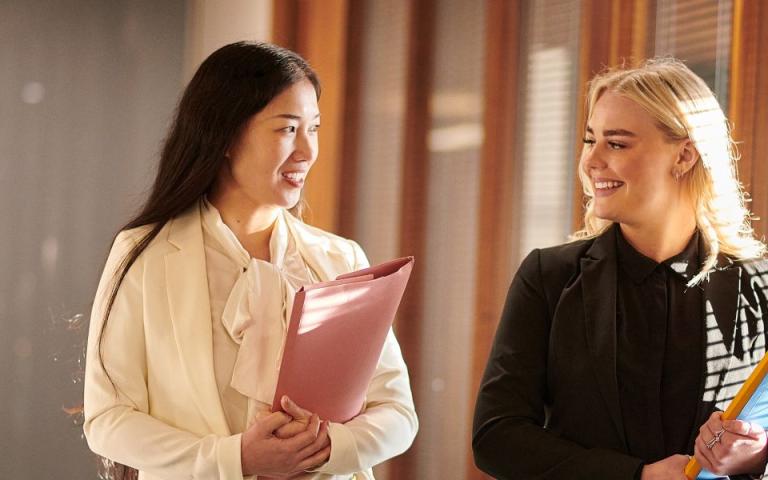 Two lawyers walk and hold documents 