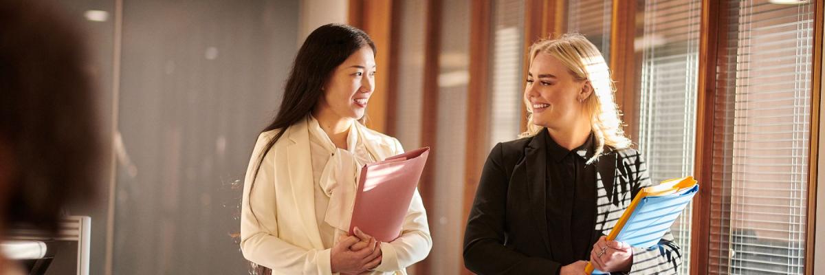 Two lawyers walk and hold documents 