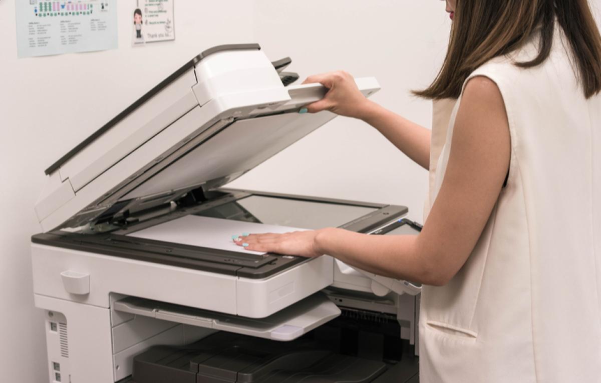 woman scanning document with multifunction printer