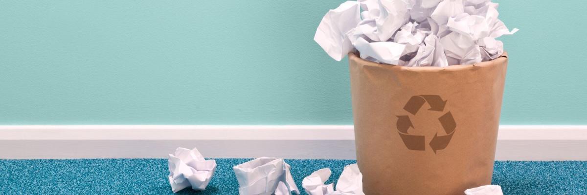 Balled up papers near recycling bin