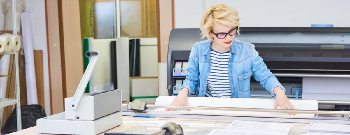 Woman working with wide format printer.